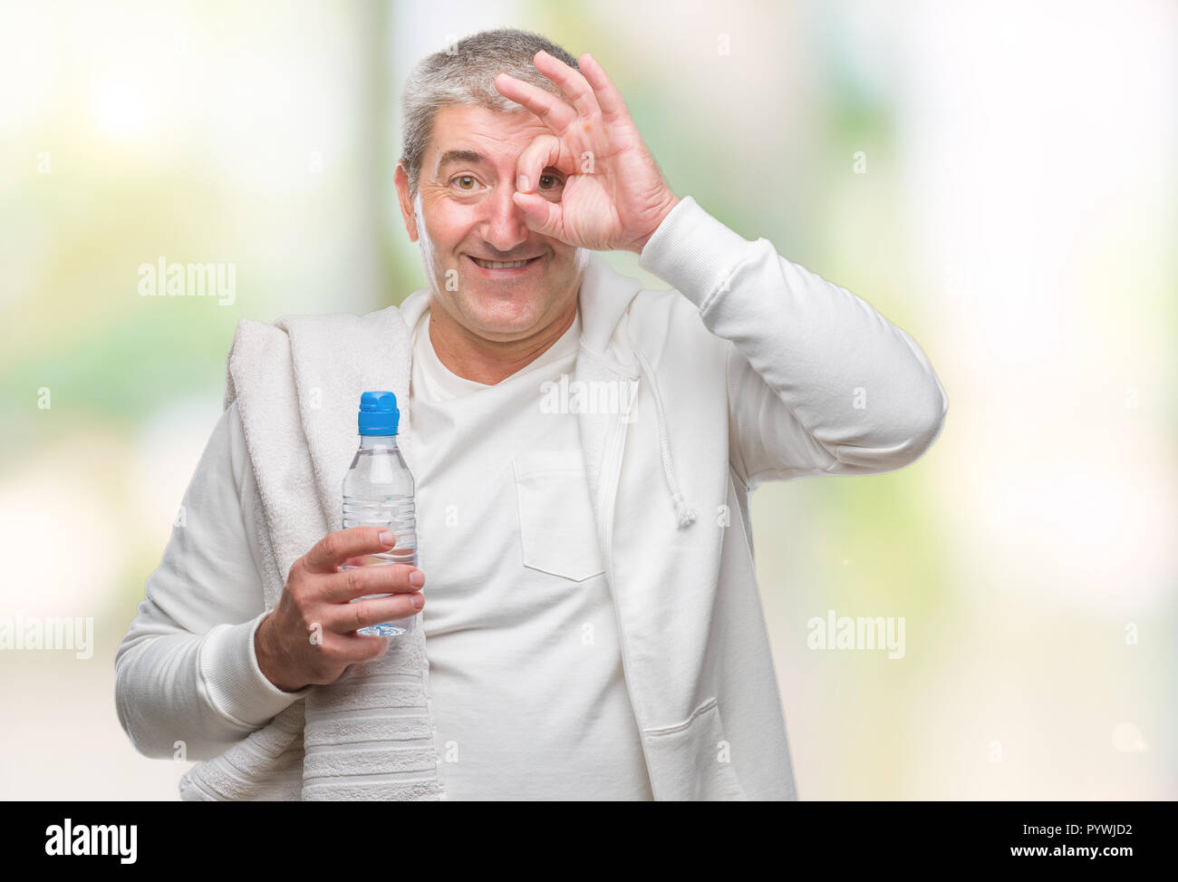 Handsome man holding formation serviette et bouteille d'eau au fond isolé avec happy smiling face ok faire signer avec la main sur l'œil à la th Banque D'Images