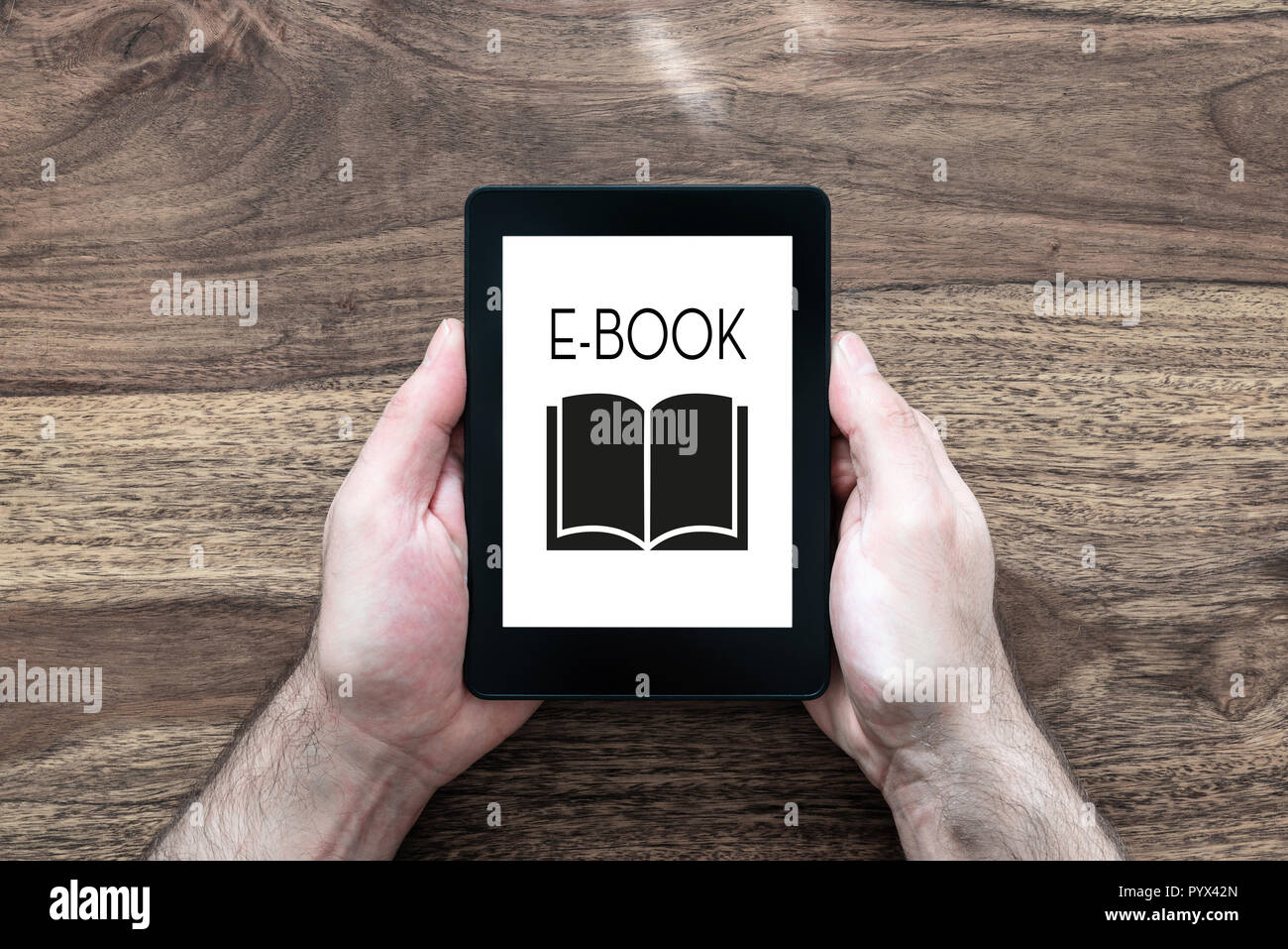Man holding e-book reader sur table en bois rustique Banque D'Images