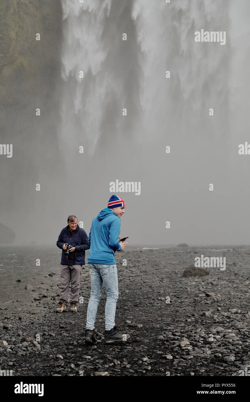 Les touristes visitant la célèbre cascade de Skogafoss dans le sud de l'Islande. Banque D'Images