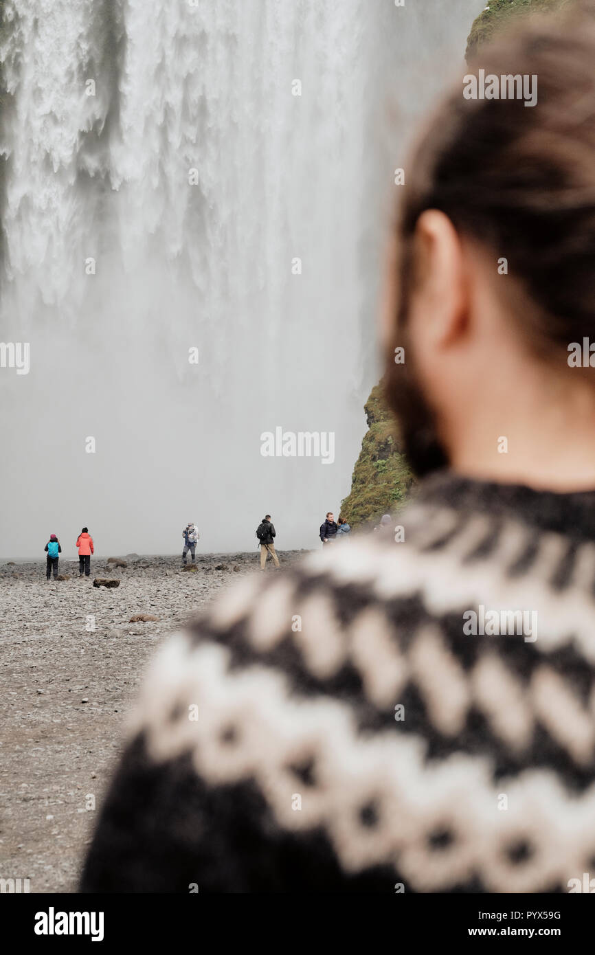 Un guide touristique islandaise traditionnelle Lopapeysa portant un chandail de laine islandaise à Skogafoss chute d'eau dans le sud de l'Islande. Version Focus Banque D'Images