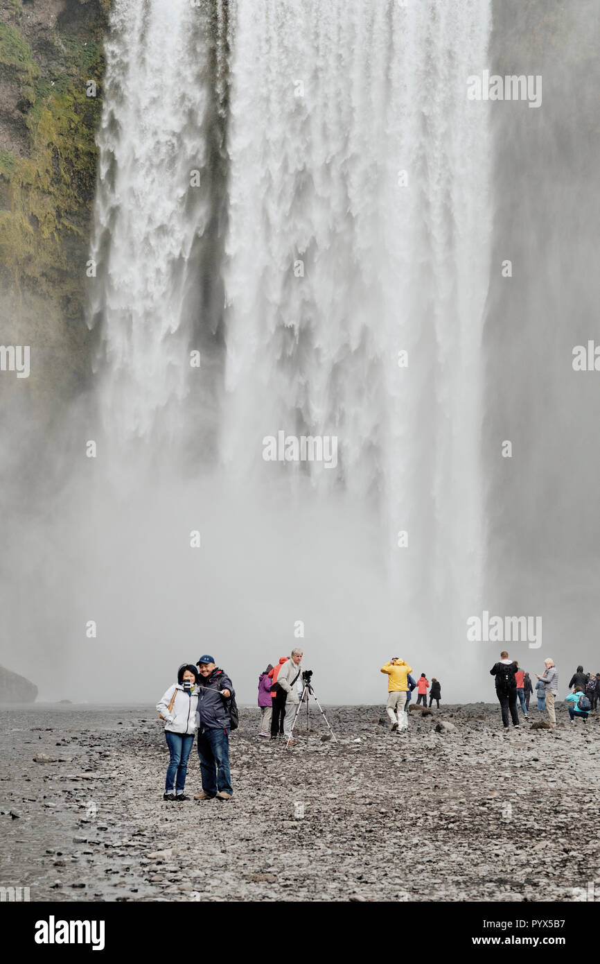 Les touristes visitant la célèbre cascade de Skogafoss dans le sud de l'Islande. Banque D'Images