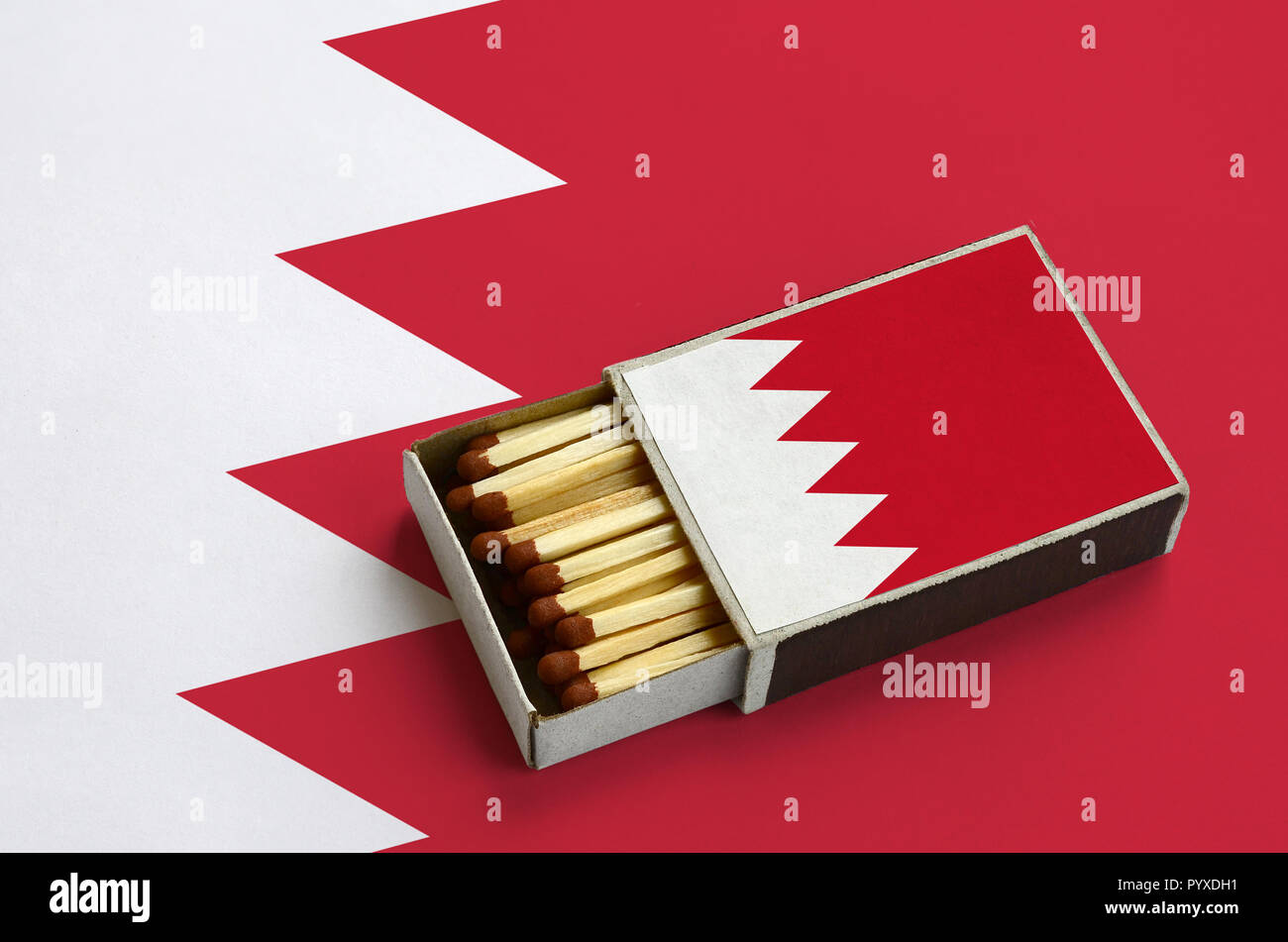 Drapeau de Bahreïn est illustré dans une boîte d'allumettes, qui est rempli avec des allumettes et se trouve sur un grand drapeau. Banque D'Images