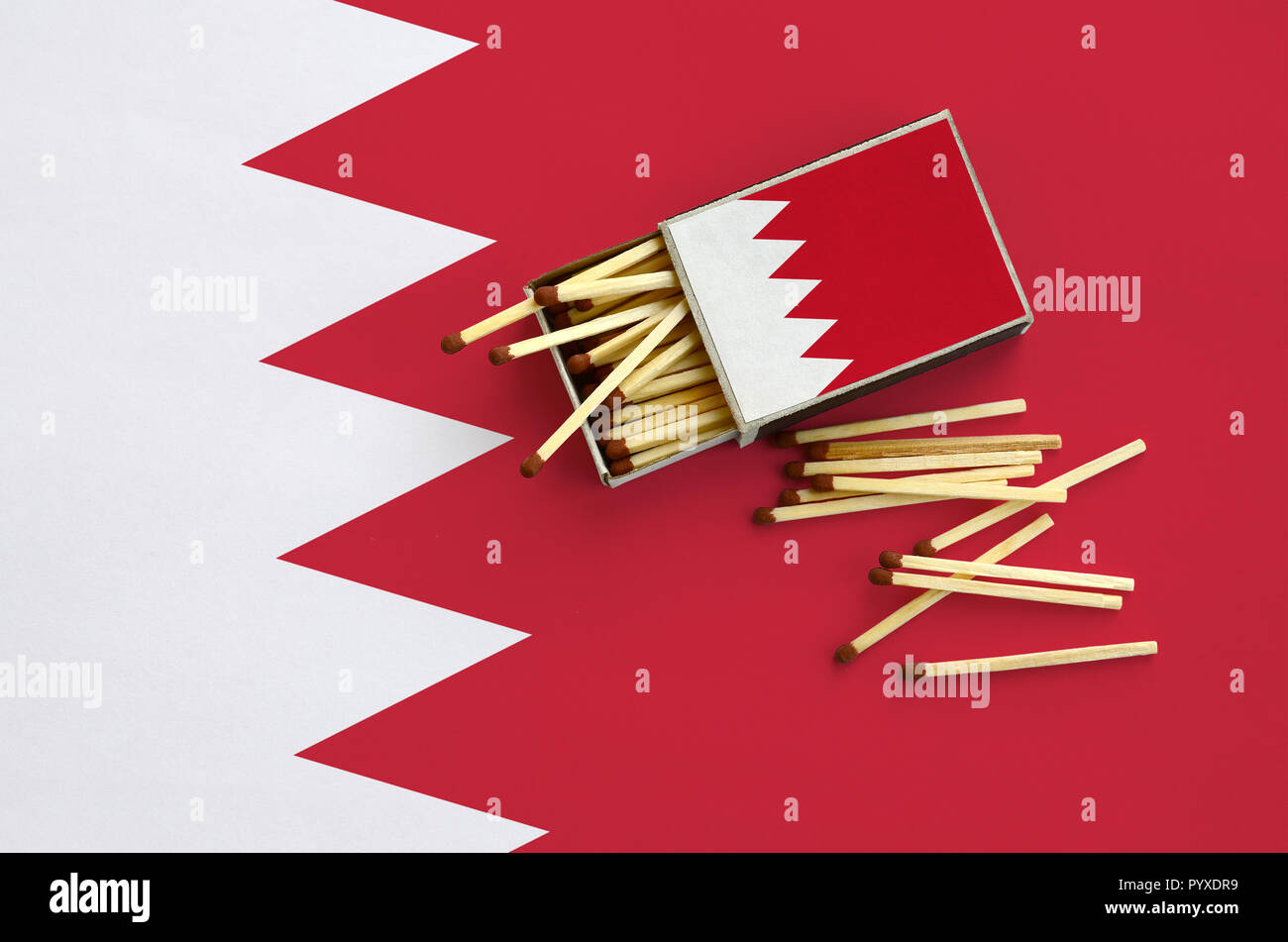 Drapeau de Bahreïn est indiqué sur une boîte d'allumettes, à partir de laquelle plusieurs matches de l'automne et se trouve sur un grand drapeau. Banque D'Images