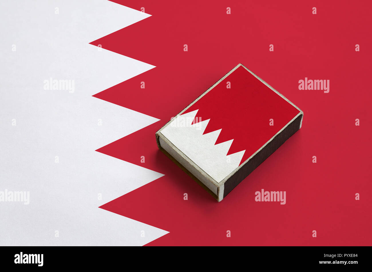 Drapeau de Bahreïn est représenté sur une boîte d'allumettes qui se trouve sur un grand drapeau. Banque D'Images