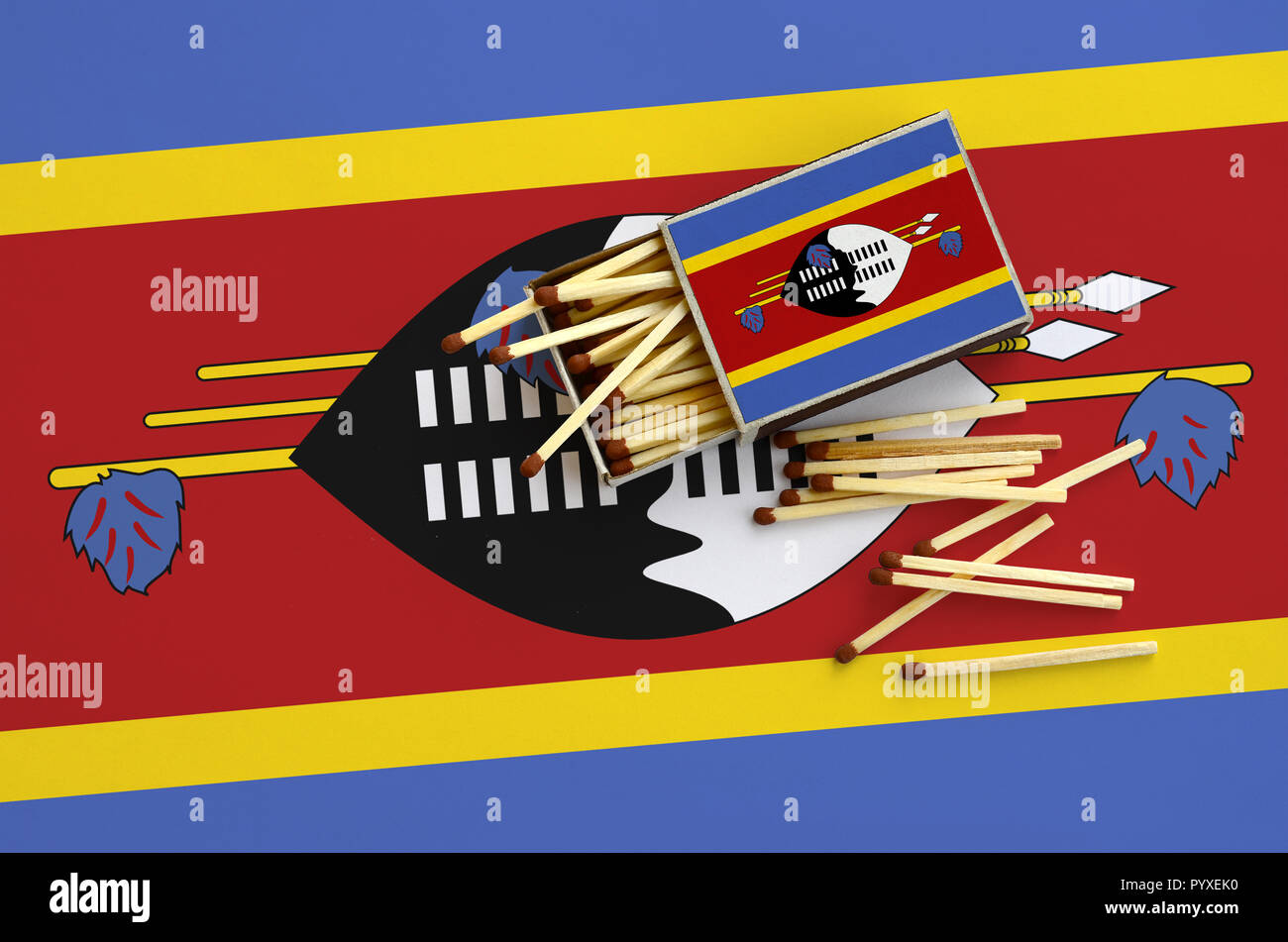 Swaziland drapeau est indiqué sur une boîte d'allumettes, à partir de laquelle plusieurs matches de l'automne et se trouve sur un grand drapeau. Banque D'Images