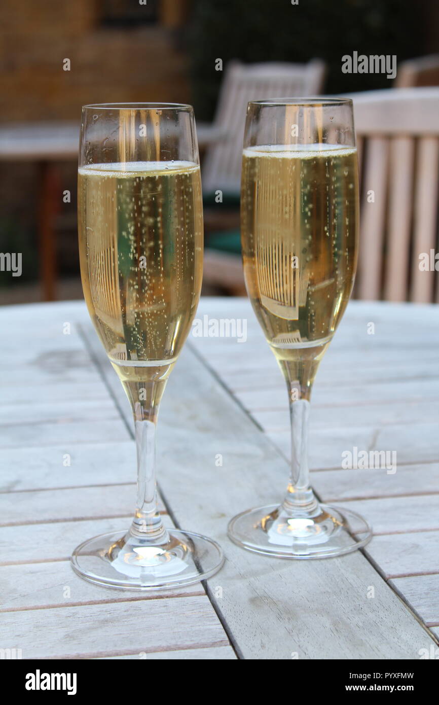 Deux flûtes de champagne assis sur table de pique-nique en bois Banque D'Images