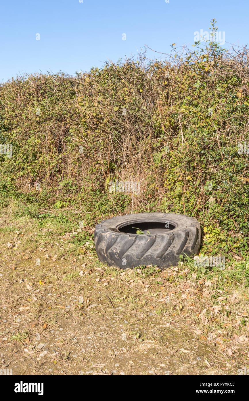 Pneu de tracteur isolé unique sur le côté d'un champ agricole, Royaume-Uni. Banque D'Images