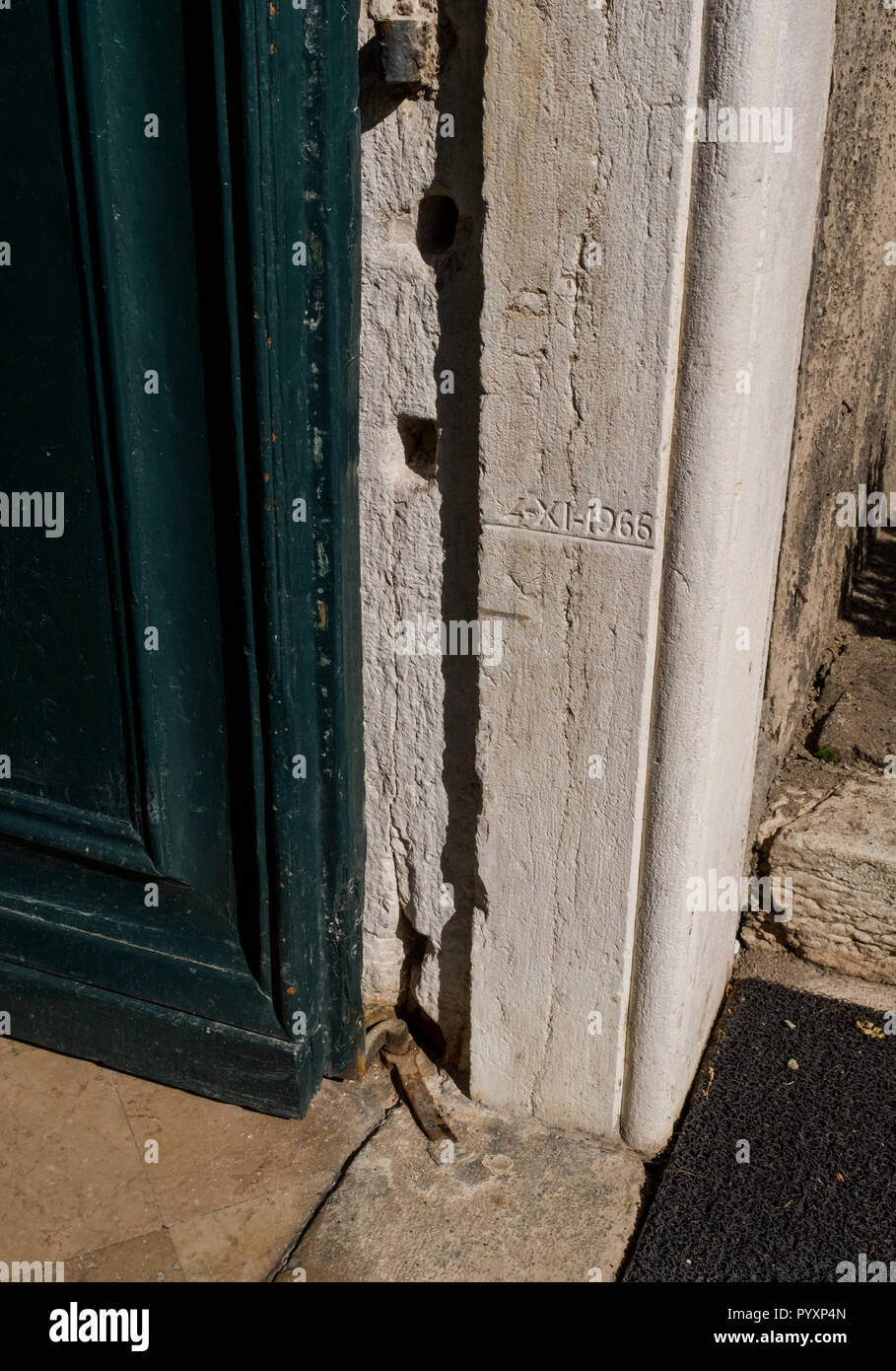 Une gravure sur un encadrement de porte en pierre marque le niveau d'eau de l'inondation de 1966 à Venise, Italie Banque D'Images