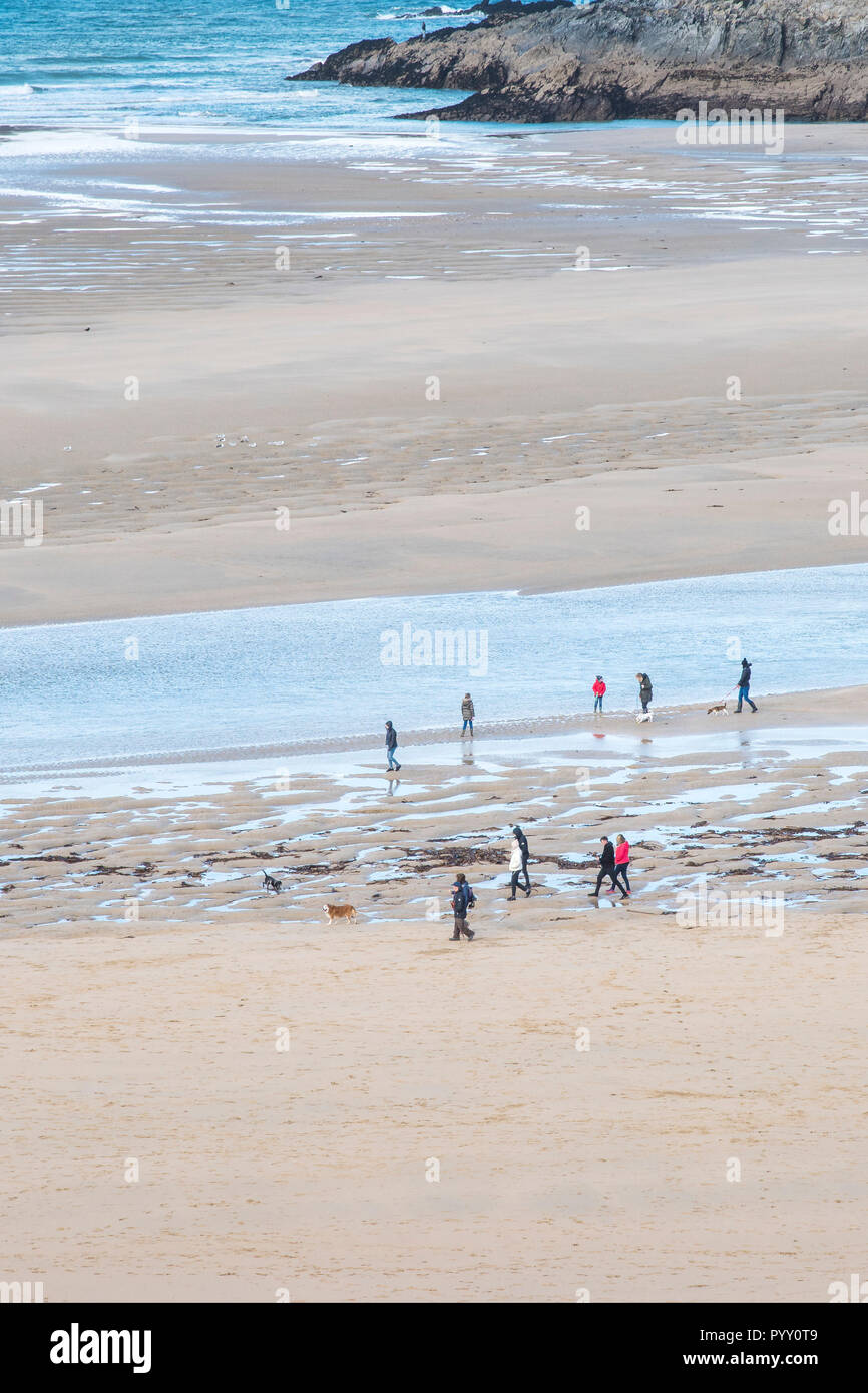 Les marcheurs vu de loin marcher le long de la rivière plage de Crantock sur Gannel à Newquay en Cornouailles. Banque D'Images