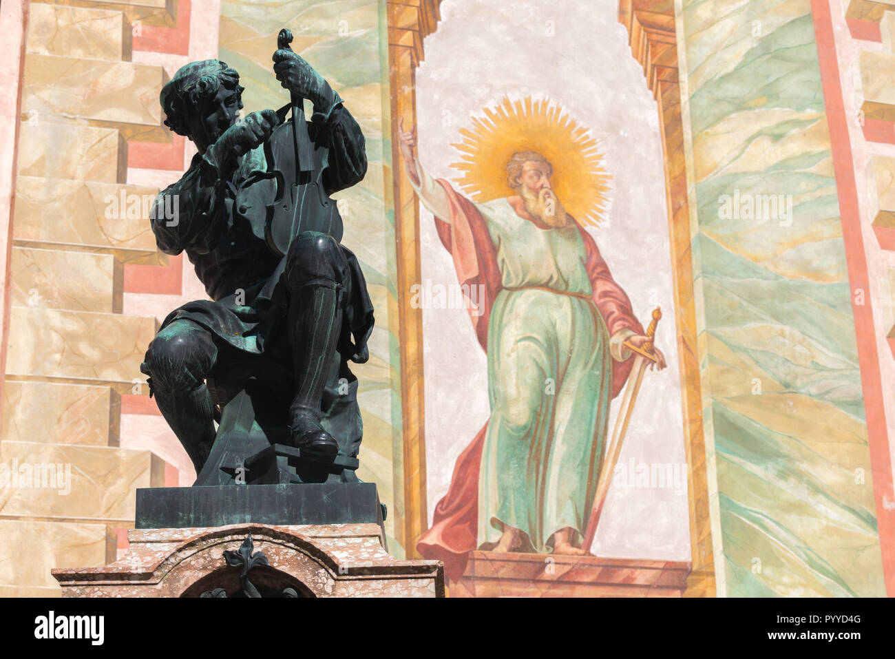 Statue d'un luthier et peinture murale sur le clocher de l'église paroissiale Saint-Pierre et Paul, Mittenwald, Upper Bavaria, Bavaria, Germany, Banque D'Images