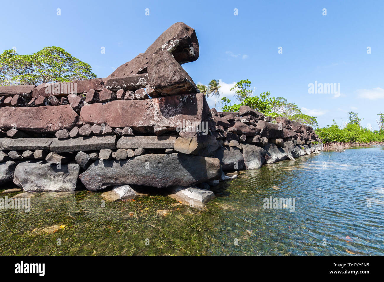 Un canal et les remparts à Nan Madol - ruines préhistoriques de la ville construite en pierre de basalte de dalles. Les murs anciens ont été construites sur des îles artificielles de corail dans le lagon de Pohnpei, Micronésie, Océanie Banque D'Images