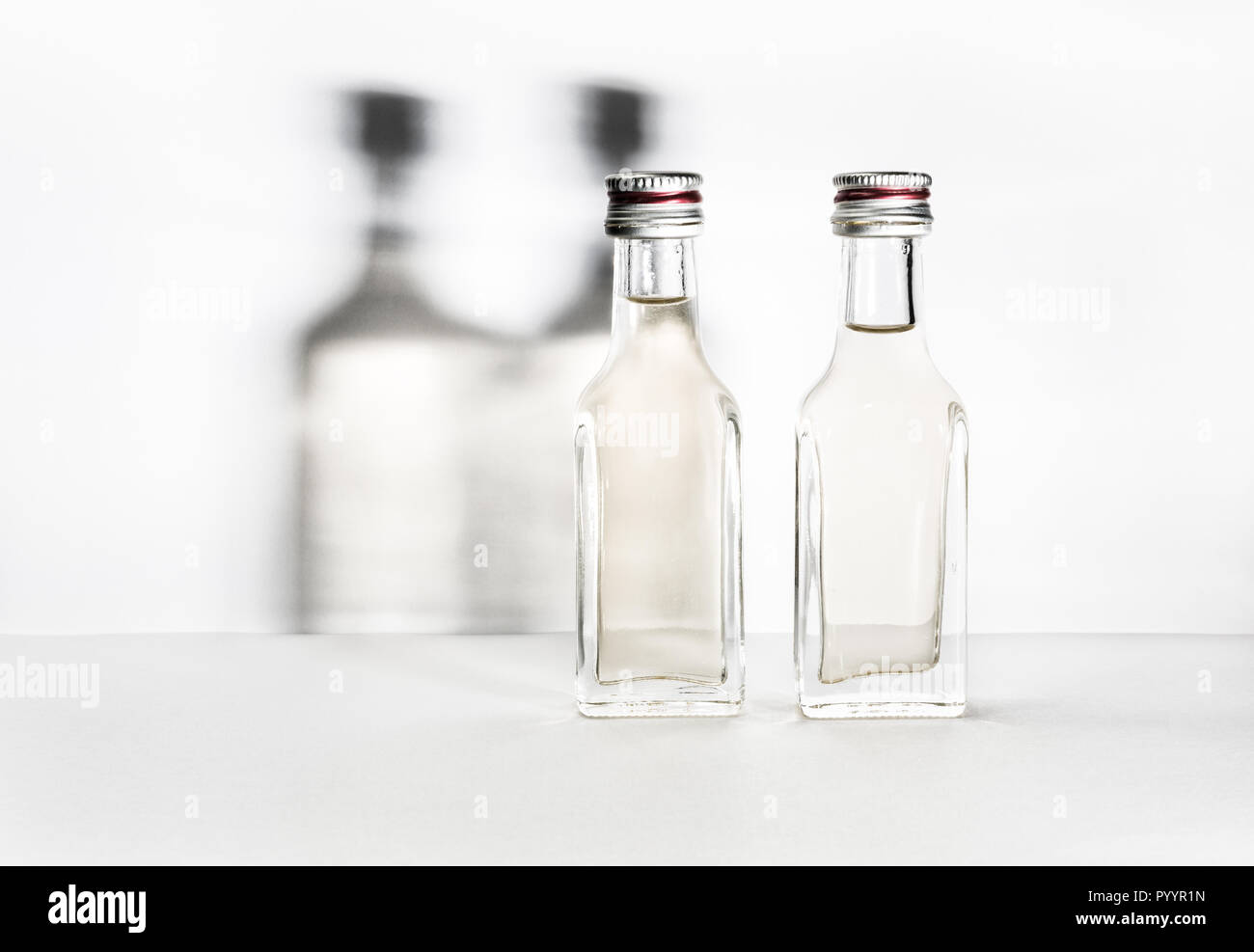 Deux bouteilles d'alcool vintage avec des ombres sur le mur. Banque D'Images