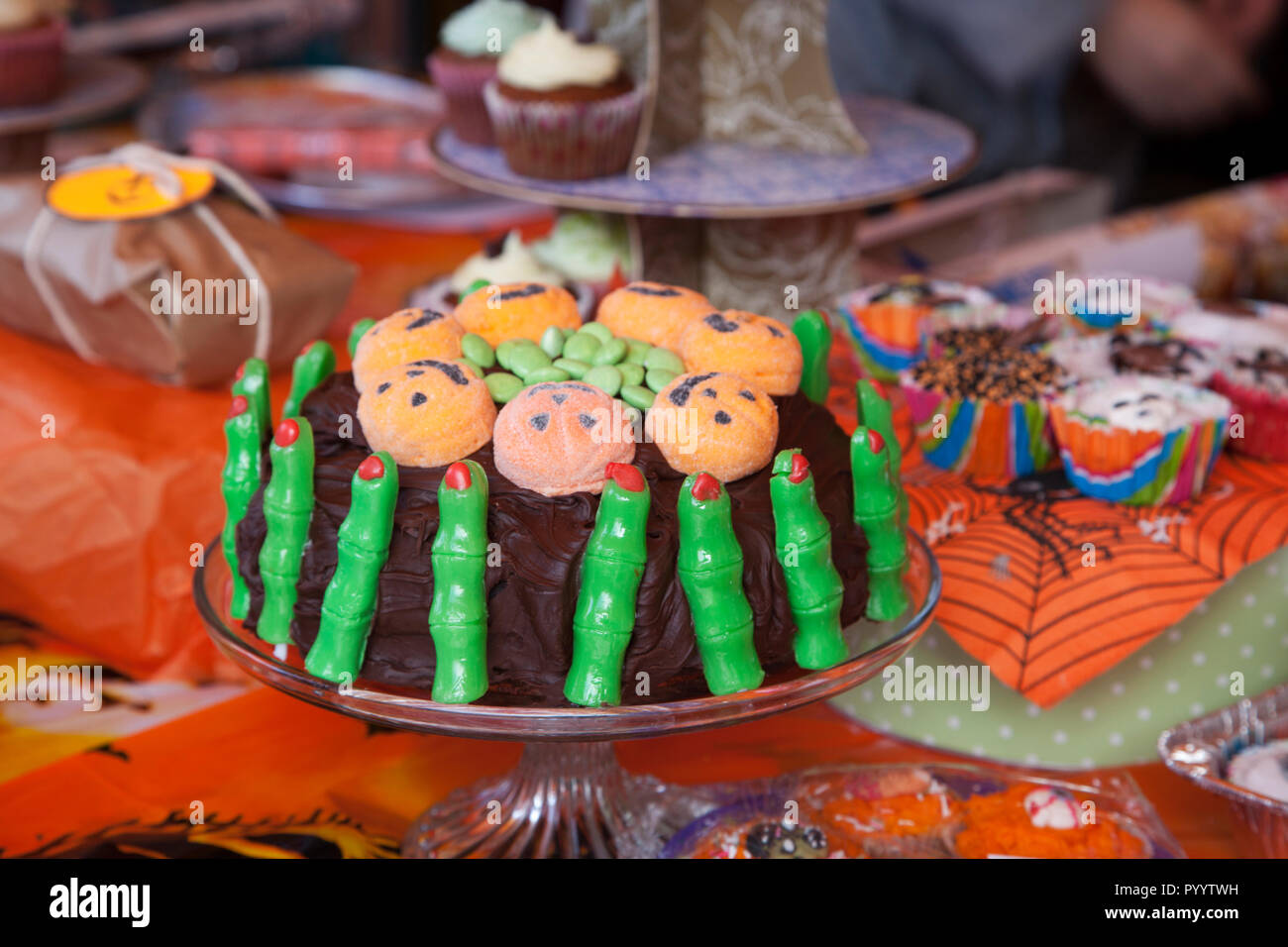 Halloween gâteau au chocolat avec les doigts verts et pumpking visages affichés avec d'autres aliments. Banque D'Images