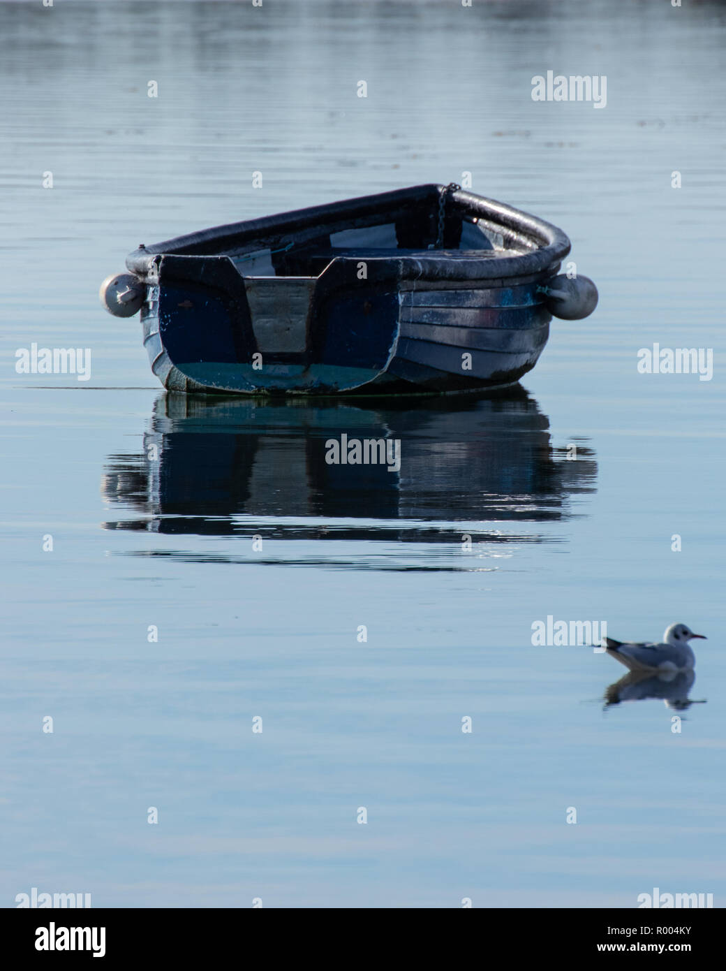 Seul un vieux bateau en bois très réfléchissant sur eaux calmes Banque D'Images