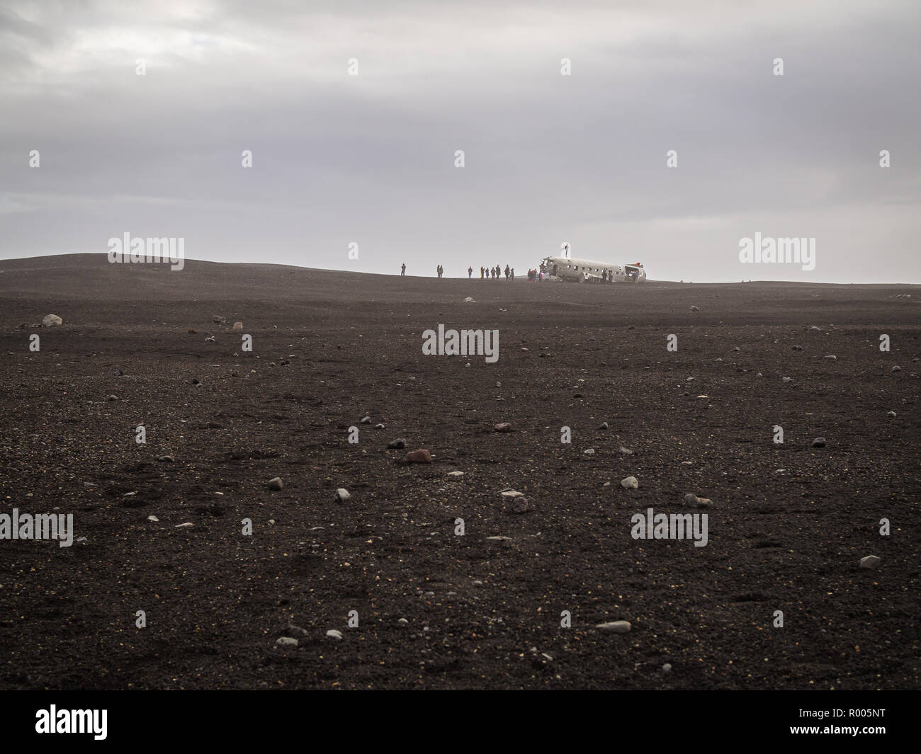 Touristes sur l'avion écrasé abandonnés en Islande en désert de sable noir Banque D'Images