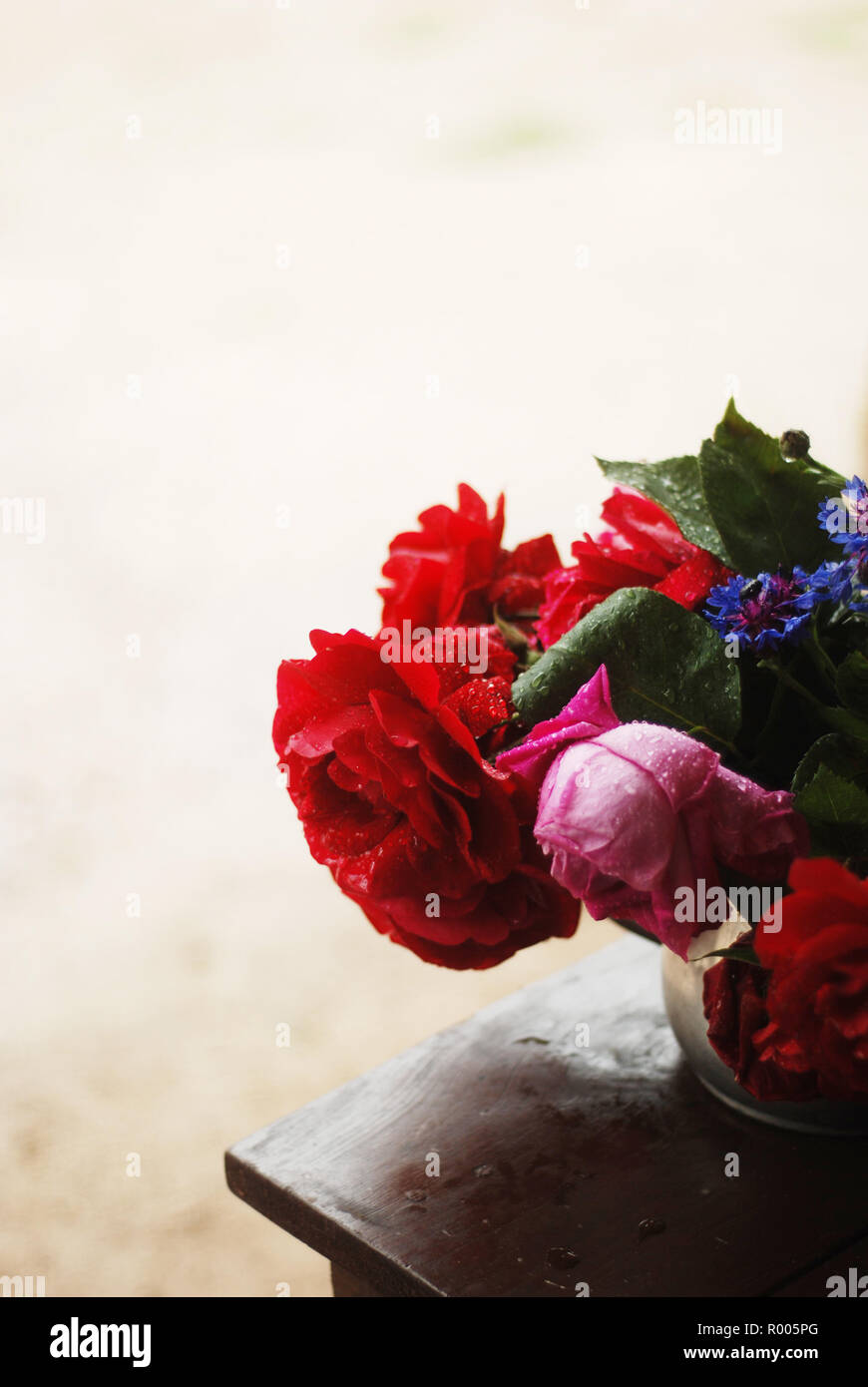 Bouquet de fleurs riches sur une table dans la palette rouge Banque D'Images