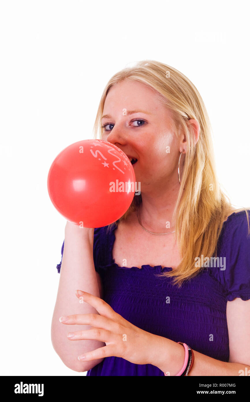 Jeune femme blonde qui souffle dans un ballon rouge Photo Stock - Alamy