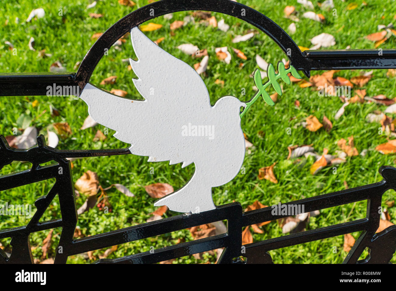 Symbole de paix, une colombe blanche avec Laurel branch conçu dans le métal à l'arrière du banc de la Temple Gardens Rhayader Powys Pays de Galles au Royaume-Uni. Banque D'Images