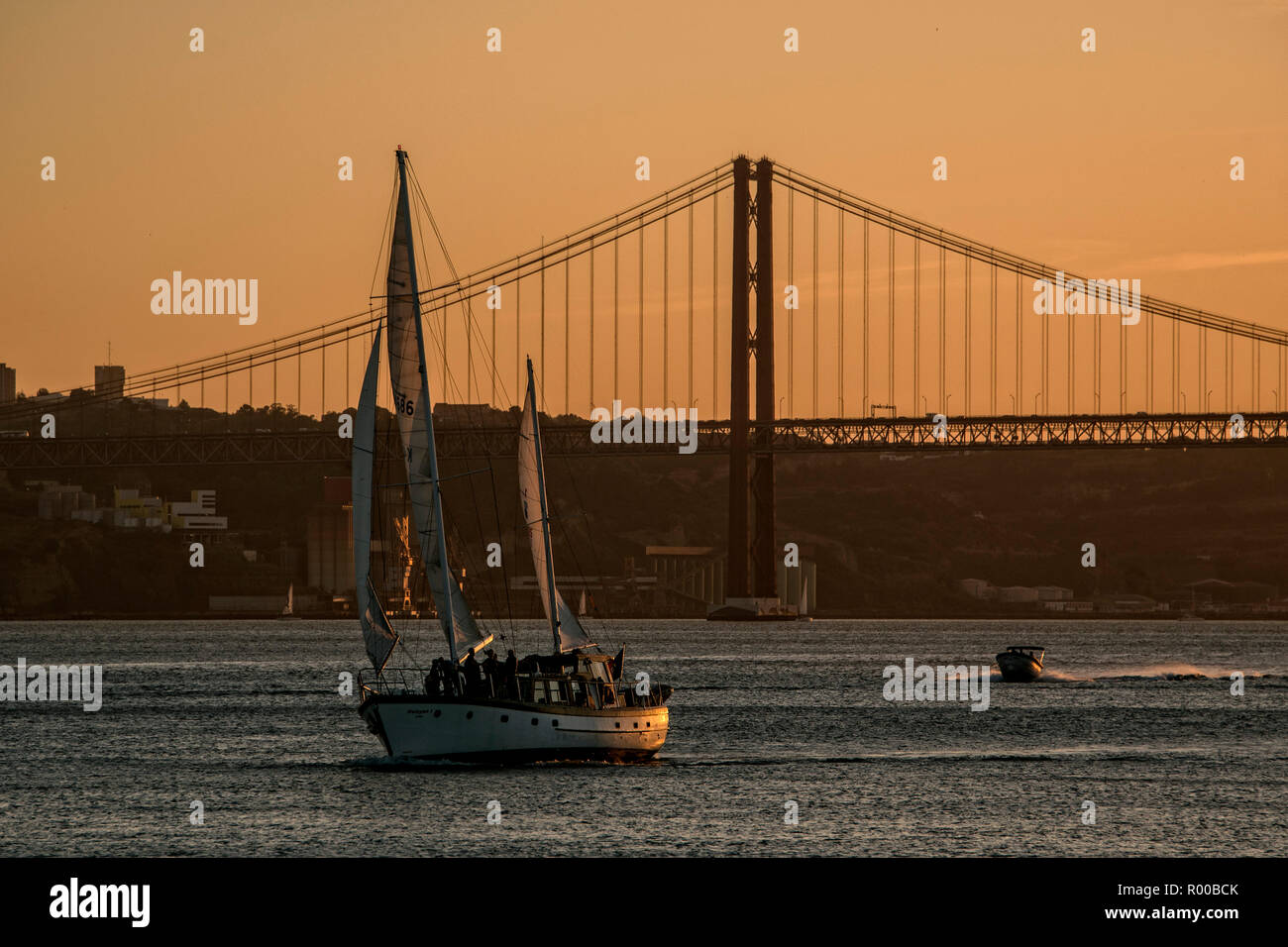 Ambiance du soir sur le Tage (Rio Tejo) avec voilier et le Ponte 25 de Abril pont suspendu, Lisbonne, Portugal. Banque D'Images