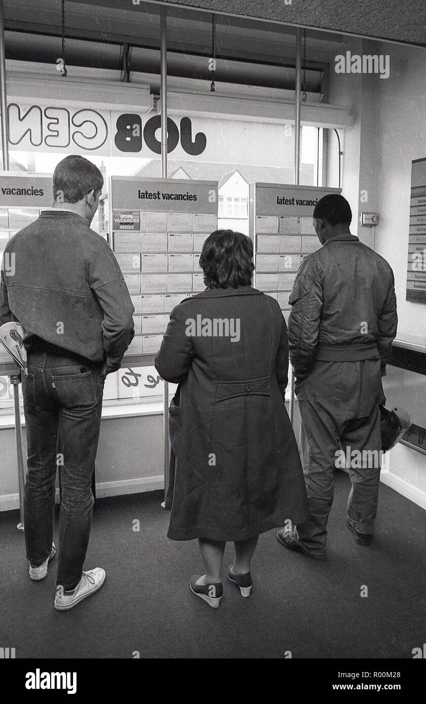 1983, à l'intérieur d'un ministère britannique de l'emploi Jobcentre, une femme et deux hommes et l'étude des cartes d'affichage des informations sur l'emploi ou d'emploi débouchés disponibles, Lewisham, dans le sud de Londres, Angleterre, Royaume-Uni. Banque D'Images