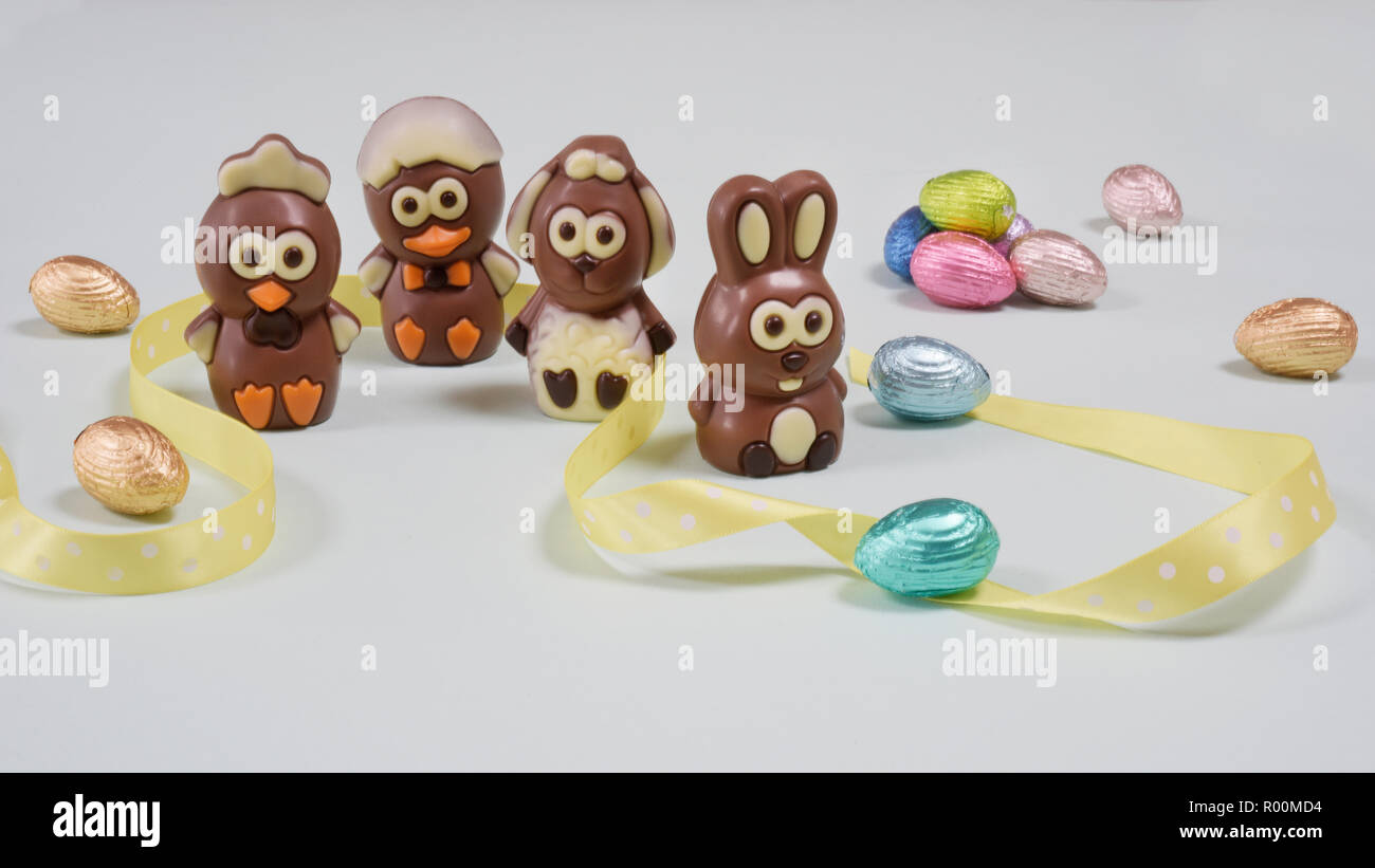 Chocolats de Pâques quatre personnages de chiffres compositionswith et ruban jaune d'oeufs de Pâques Banque D'Images