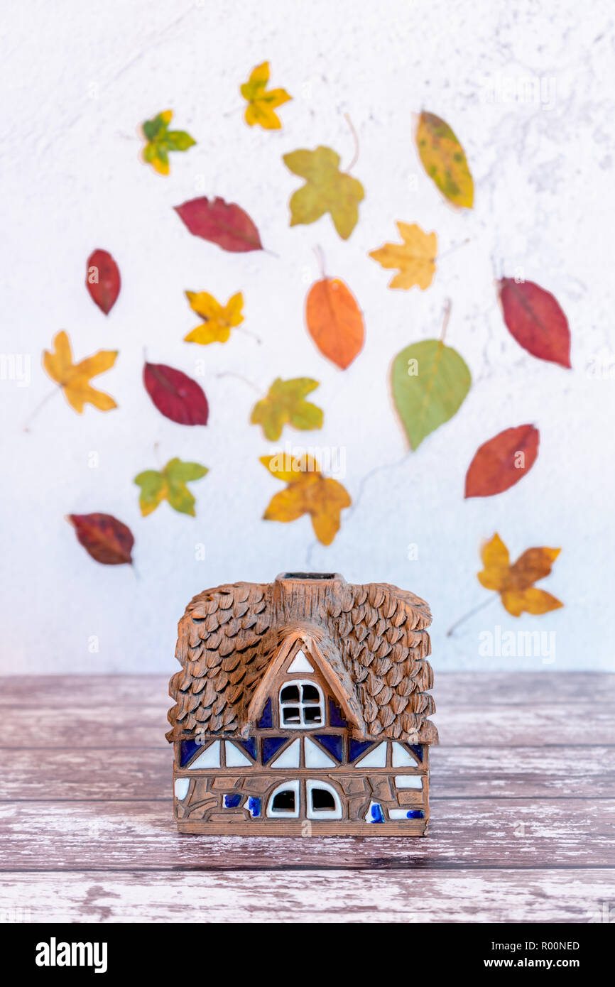 Concept d'automne - maison miniature avec motif de feuilles d'automne / feuillage dans l'arrière-plan - scène d'automne Banque D'Images