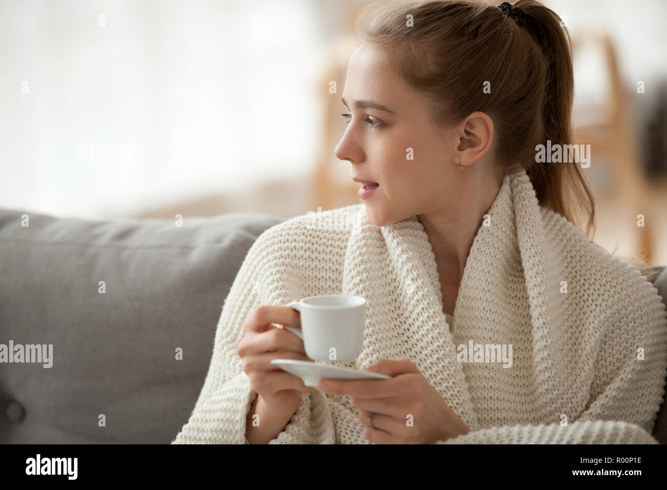 Attractive Woman sitting on couch tenir tasse de café Banque D'Images