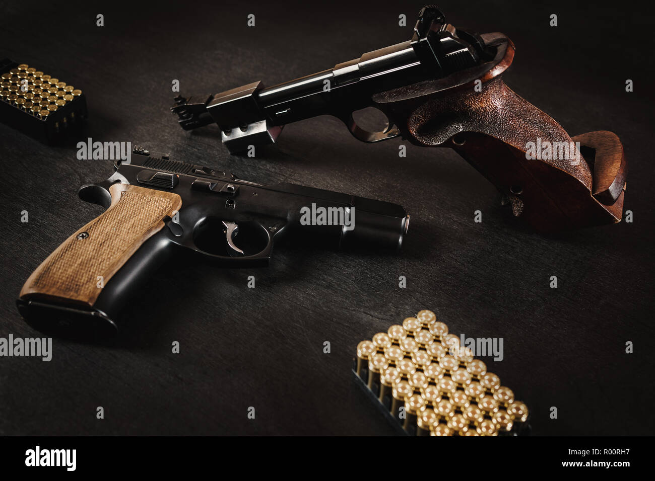 Pistolets noir et des balles sur une table en bois noir Banque D'Images