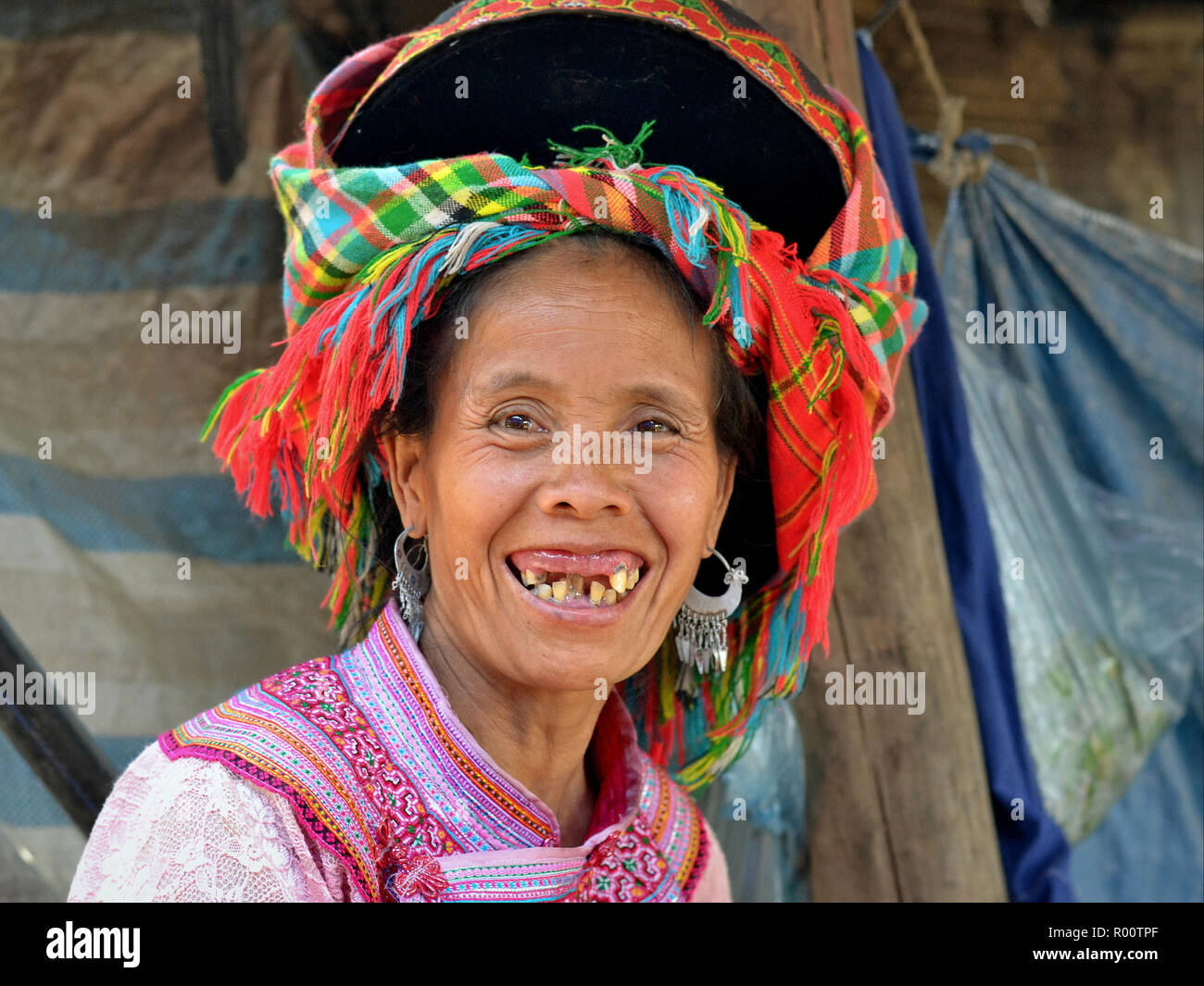 Souriant, personnes âgées des H'Mong hill-tribu femme aux boucles d'argent et de très mauvaises dents. Banque D'Images