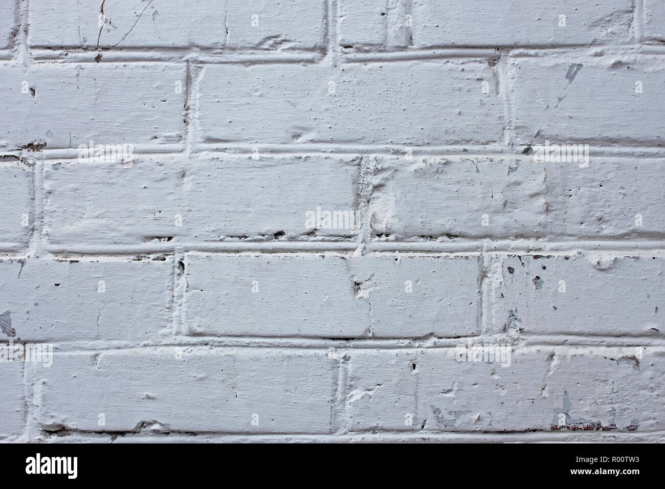 Fragment de vieux murs en brique recouverts de nombreuses couches de peinture et de chaux Banque D'Images