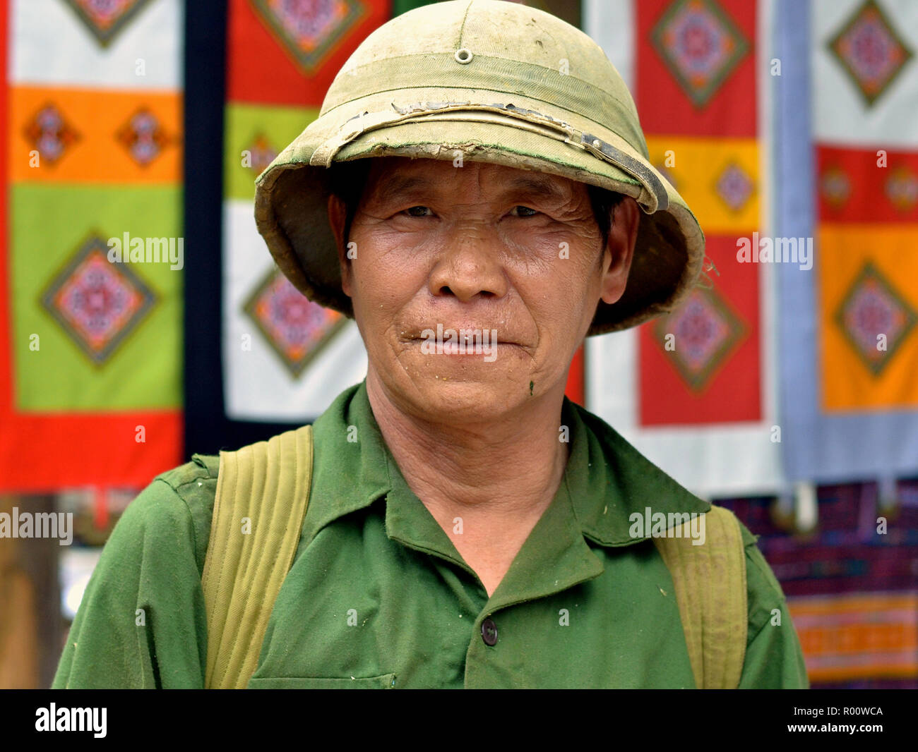 Personnes âgées Vietnamiens du Nord ancien soldat porte un vieux vert chemise militaire et un Nord Vietnam casque colonial de l'armée. Banque D'Images