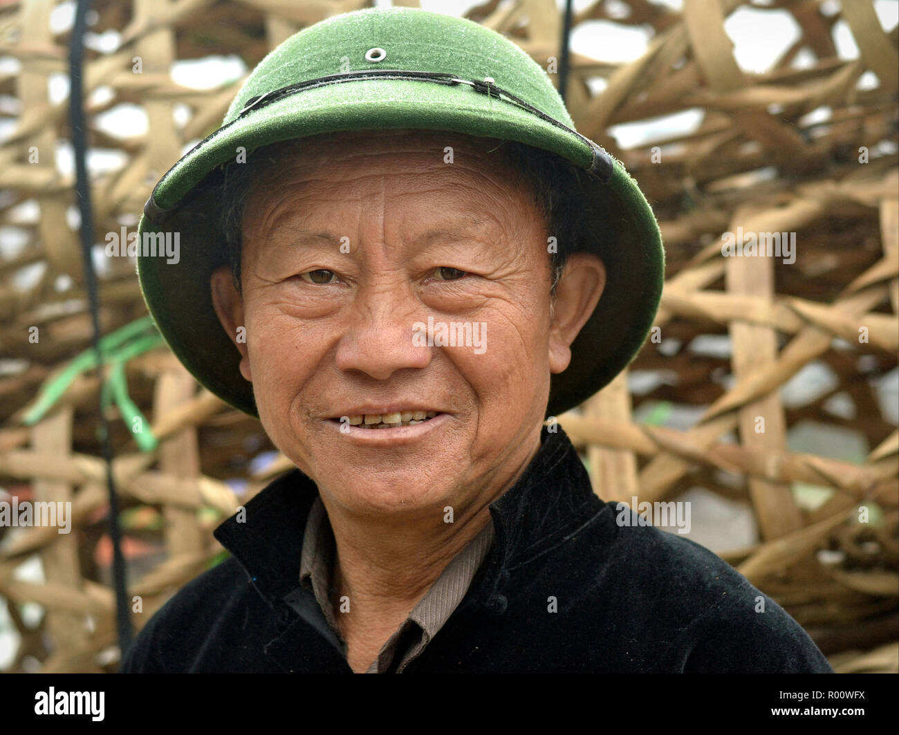 Vietnamien d'âge moyen de la communauté H'mong porte un casque colonial de l'armée du Vietnam du Nord un jour de pluie. Banque D'Images