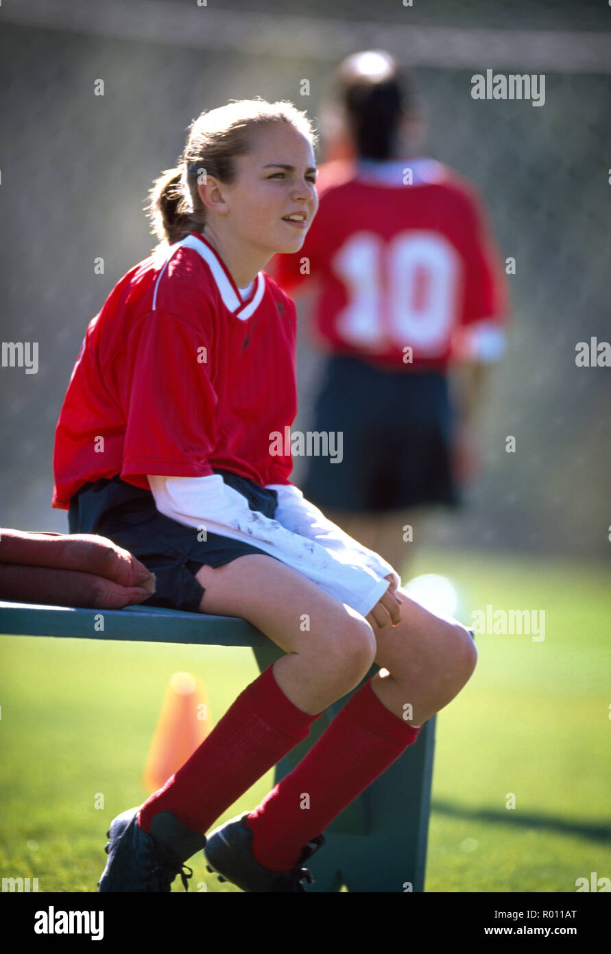 Fille assise sur un banc à l'entraînement de soccer. Banque D'Images