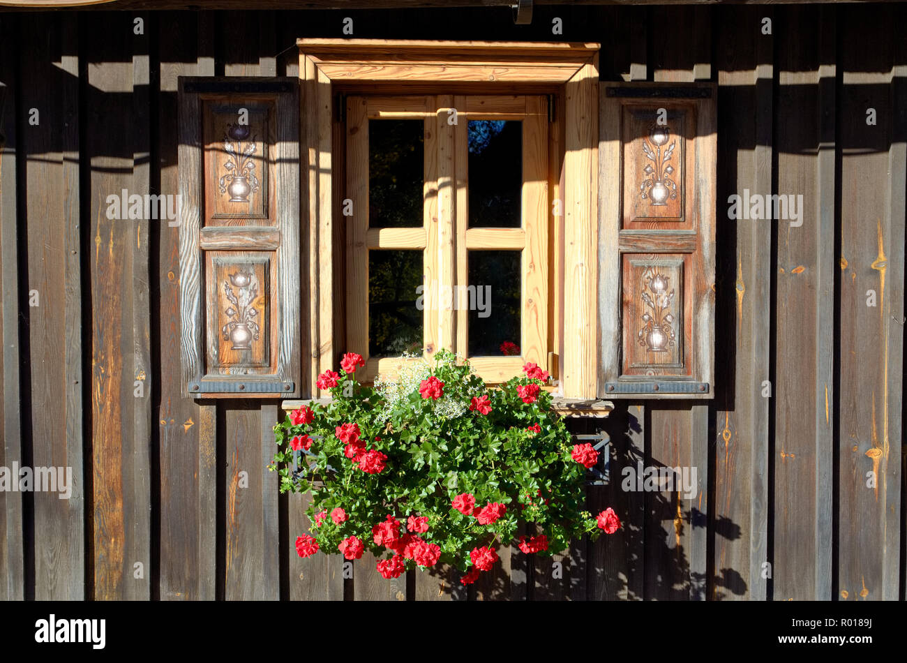 Fenêtre traditionnelle en bois avec fleur rouge Banque D'Images