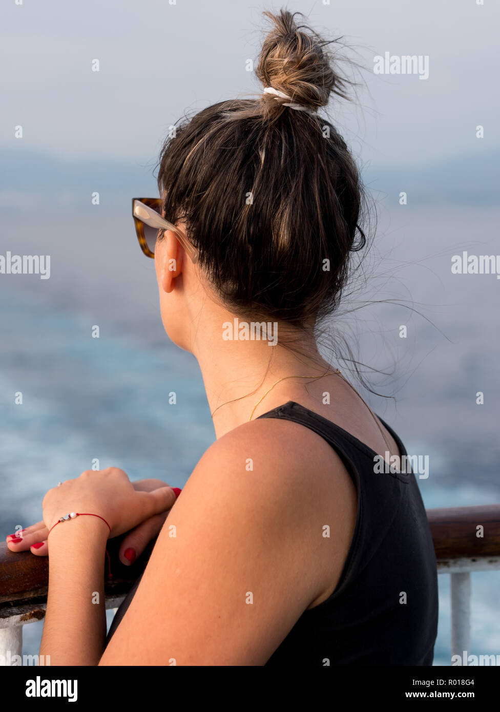Jeune femme sur le navire à la clôture à la mer de l'arrière Banque D'Images