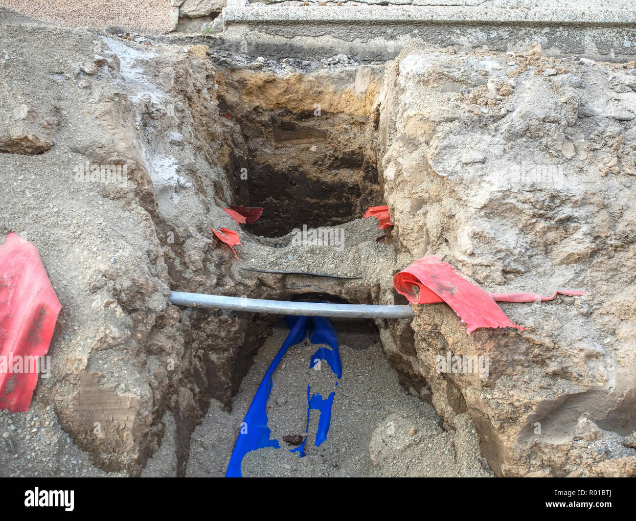 La construction de lignes de câbles à fibres optiques et métalliques de connexion au réseau de communication. La tranchée porte les conduites de gaz eau sewa électrique Banque D'Images