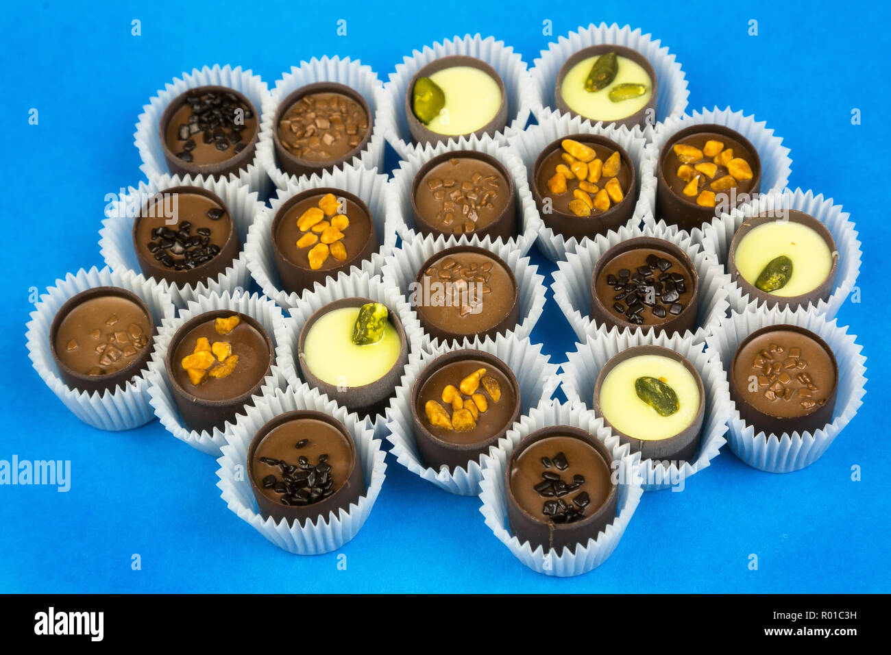 Bonbons de chocolat avec divers matériaux dans une enveloppe de papier sur un arrière-plan lumineux. Banque D'Images