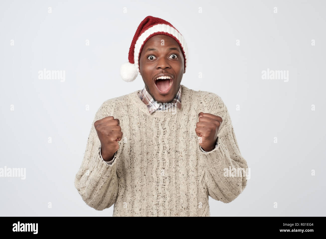 Noël drôle homme africain dans Red Hat sur fond gris Banque D'Images