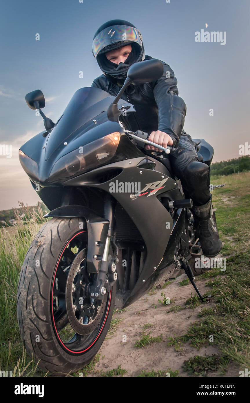 Suite noir biker et sa moto sport dans une tenue de protection noir Photo  Stock - Alamy