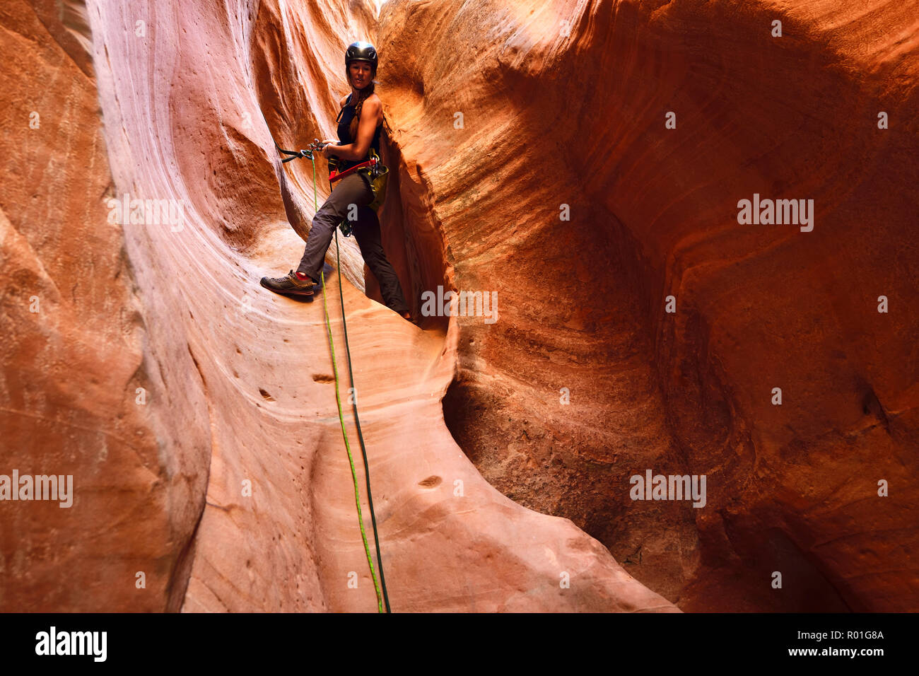 Femme de l'escalade dans le canyon à l'extérieur de l'emplacement de Huntress Zion National Park, Utah, USA Banque D'Images