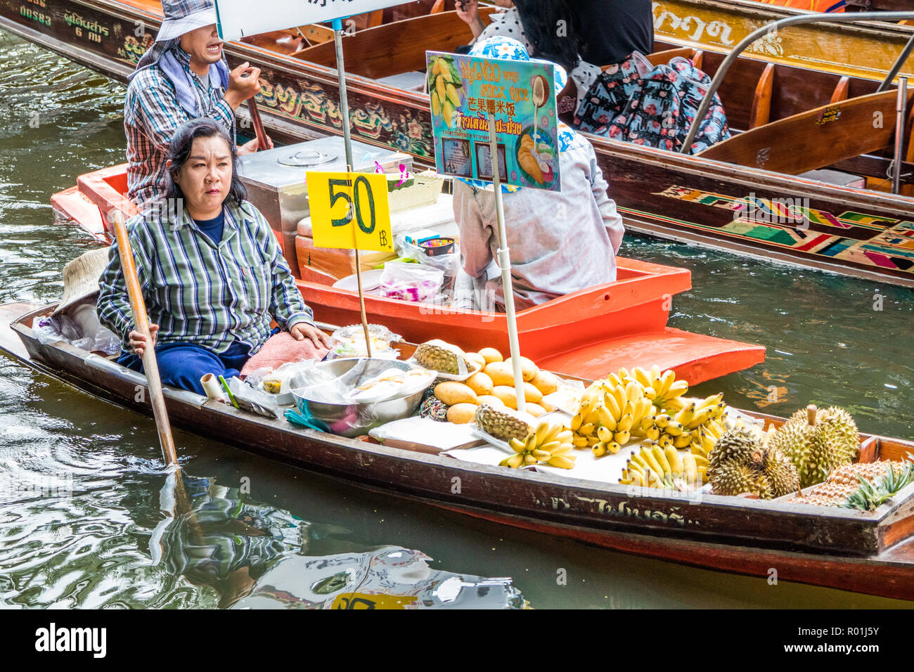 Damnoen Saduak, Thaïlande - 8 octobre 2018 : Vendeur dans le bateau qui le riz collant au marché flottant. Le marché est une destination touristique très poular Banque D'Images