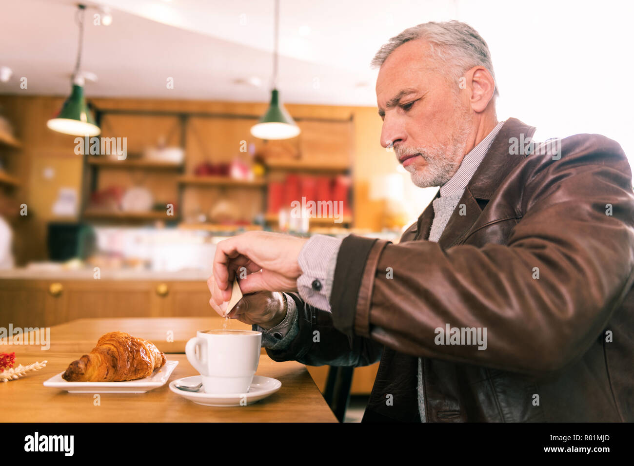 Les dépenses d'affaires aux cheveux gris matin dans French bakery Banque D'Images