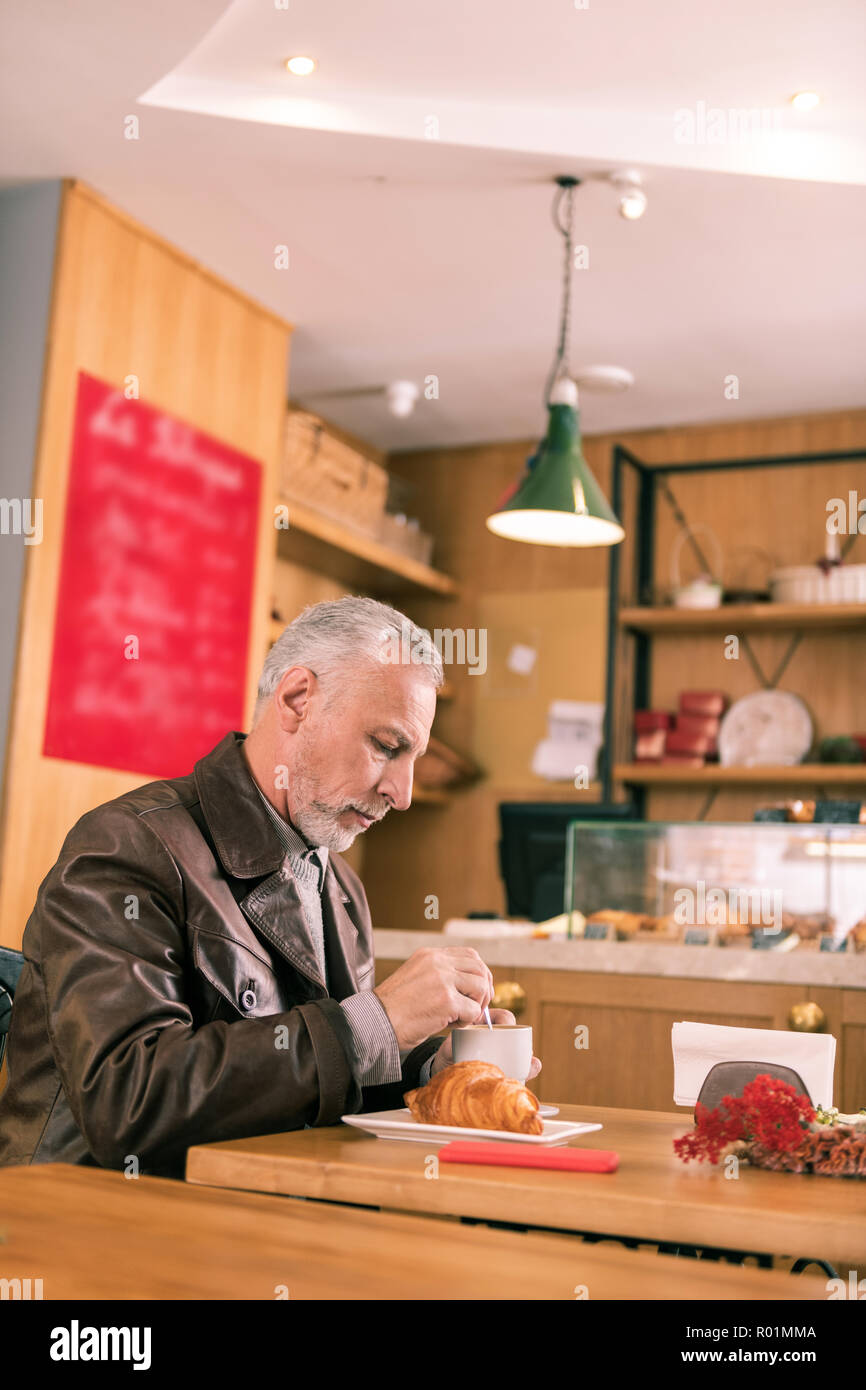 Homme aux cheveux gris en attente d'un partenaire commercial dans la région de French bakery Banque D'Images