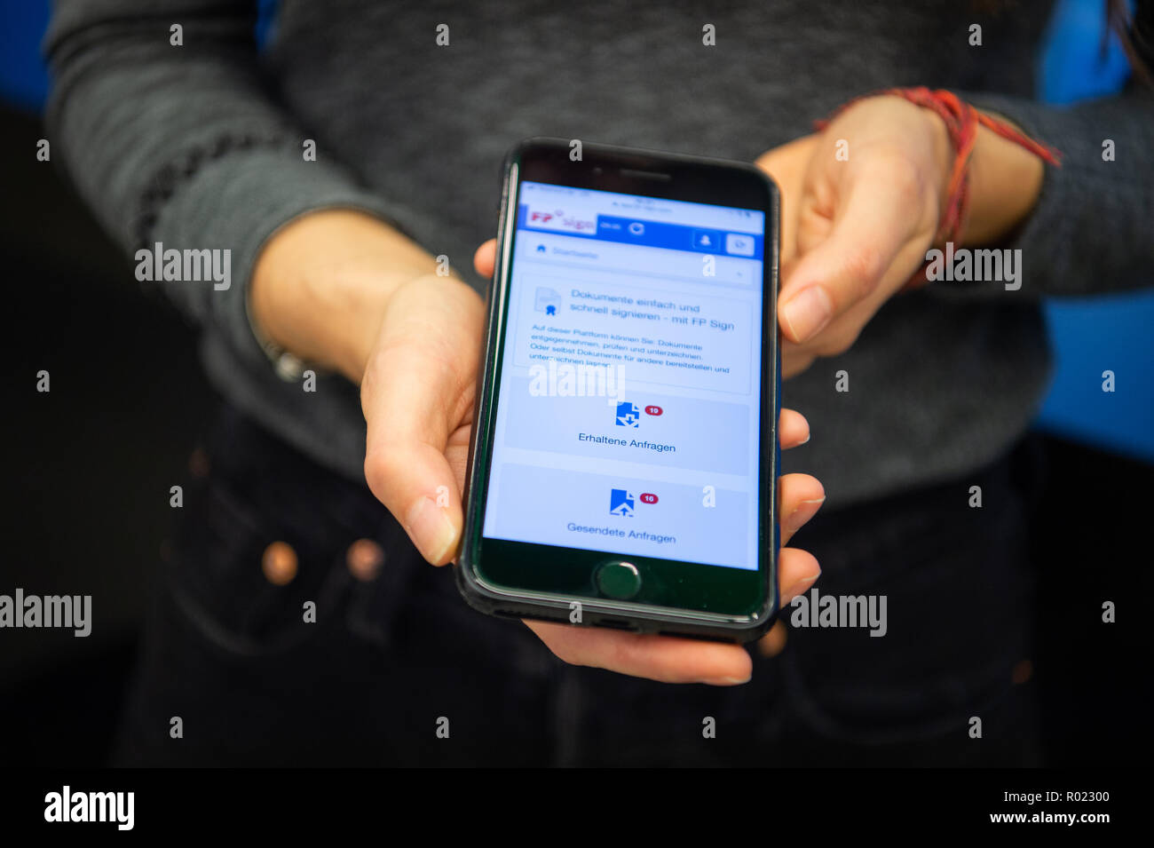 Berlin, Allemagne. 30Th Oct, 2018. Une femme est titulaire d'un téléphone mobile qui affiche la page de démarrage du navigateur de la signature solution FP signe. FP signe est une application numérique conçu pour signer les documents de façon aussi sécurisée que possible. Les entreprises et les gens d'affaires peuvent signer et contrats de change et les documents importants dans un court laps de temps. L'identité de l'expéditeur peut également être vérifiée par un certificat de Bundesdruckerei. Credit : Arne Immanuel Bänsch/dpa/Alamy Live News Banque D'Images