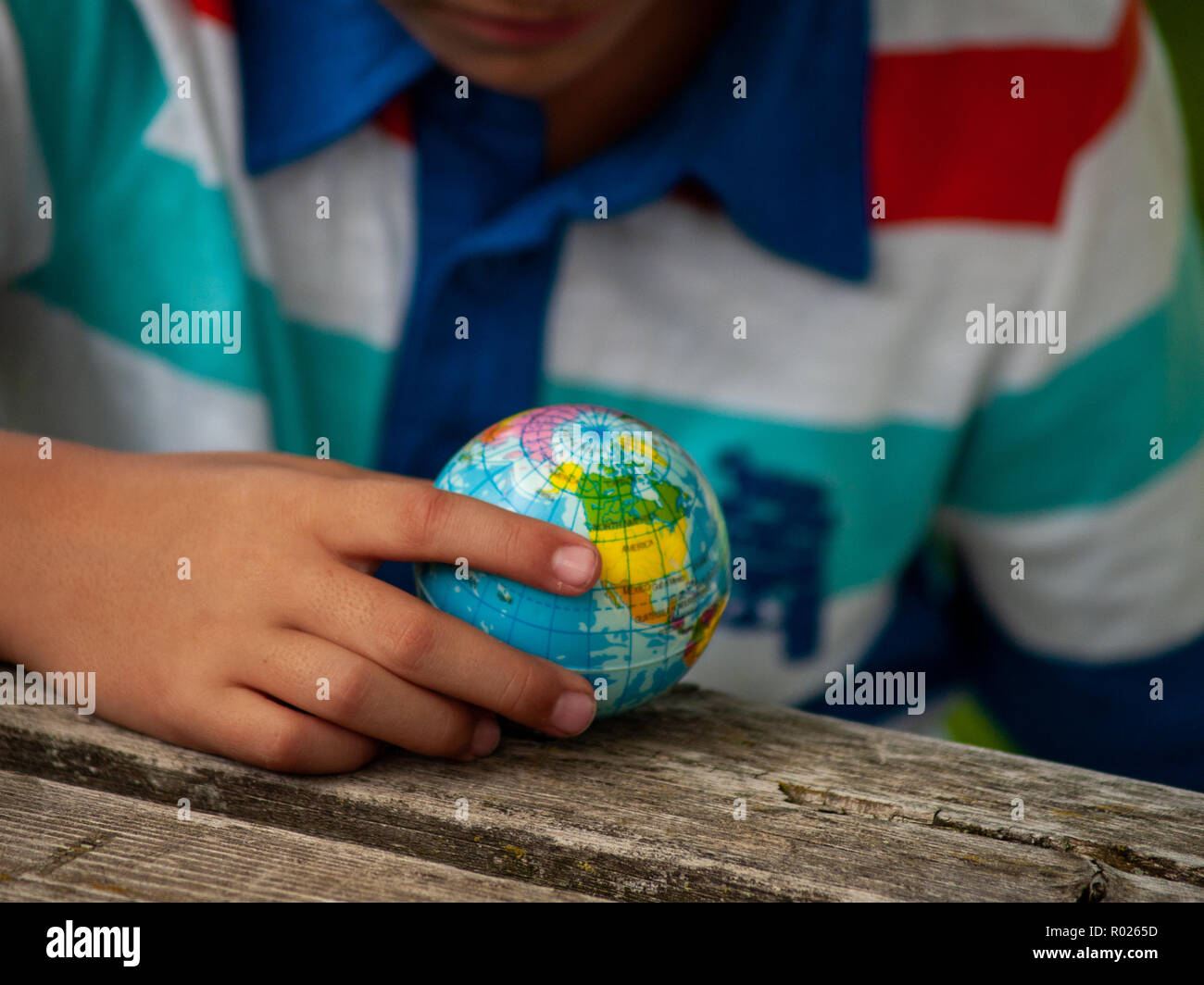 Un garçon avec une balle de l'Organisation mondiale de la planète Terre ou dans ses mains. Ecology concept Banque D'Images