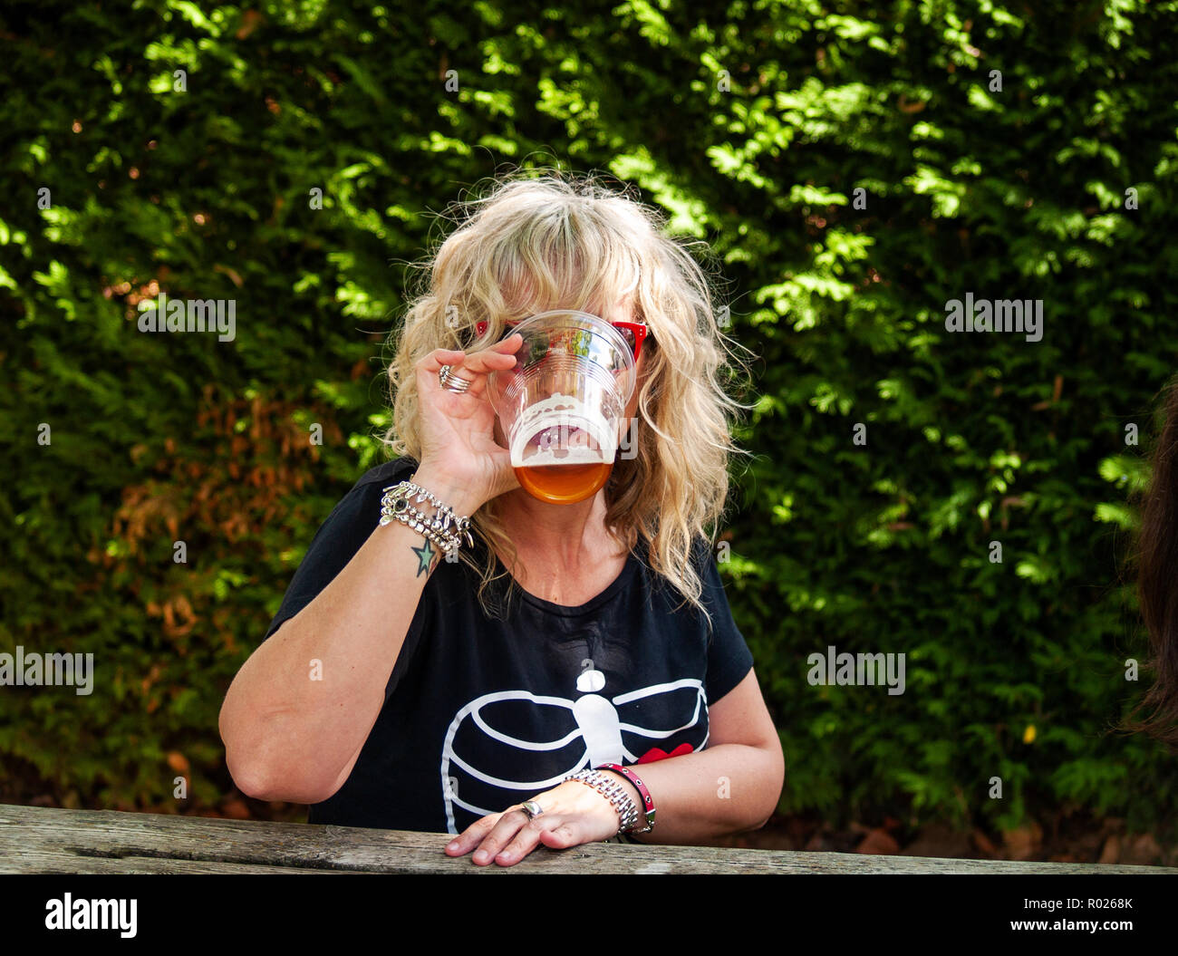 Une femme de boire de la bière lors d'une célébration en plein air Banque D'Images