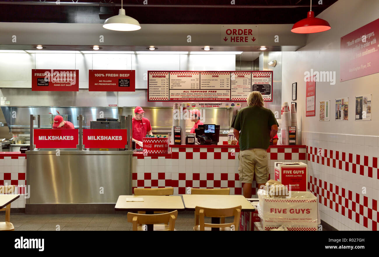Cinq gars à l'intérieur de la chaîne de restauration rapide servant des hamburgers, frites fraîches en direction de l'Ithaca NY, USA. Vente à emporter, manger dans. Banque D'Images