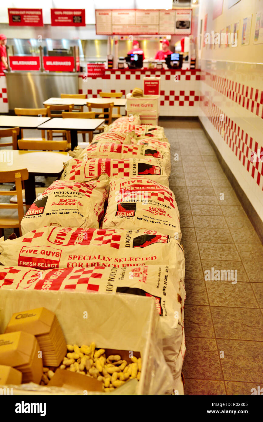 Cinq gars à l'intérieur de la chaîne de restauration rapide servant des hamburgers, frites fraîches en direction de l'Ithaca NY, USA avec des sacs de pommes de terre. Banque D'Images