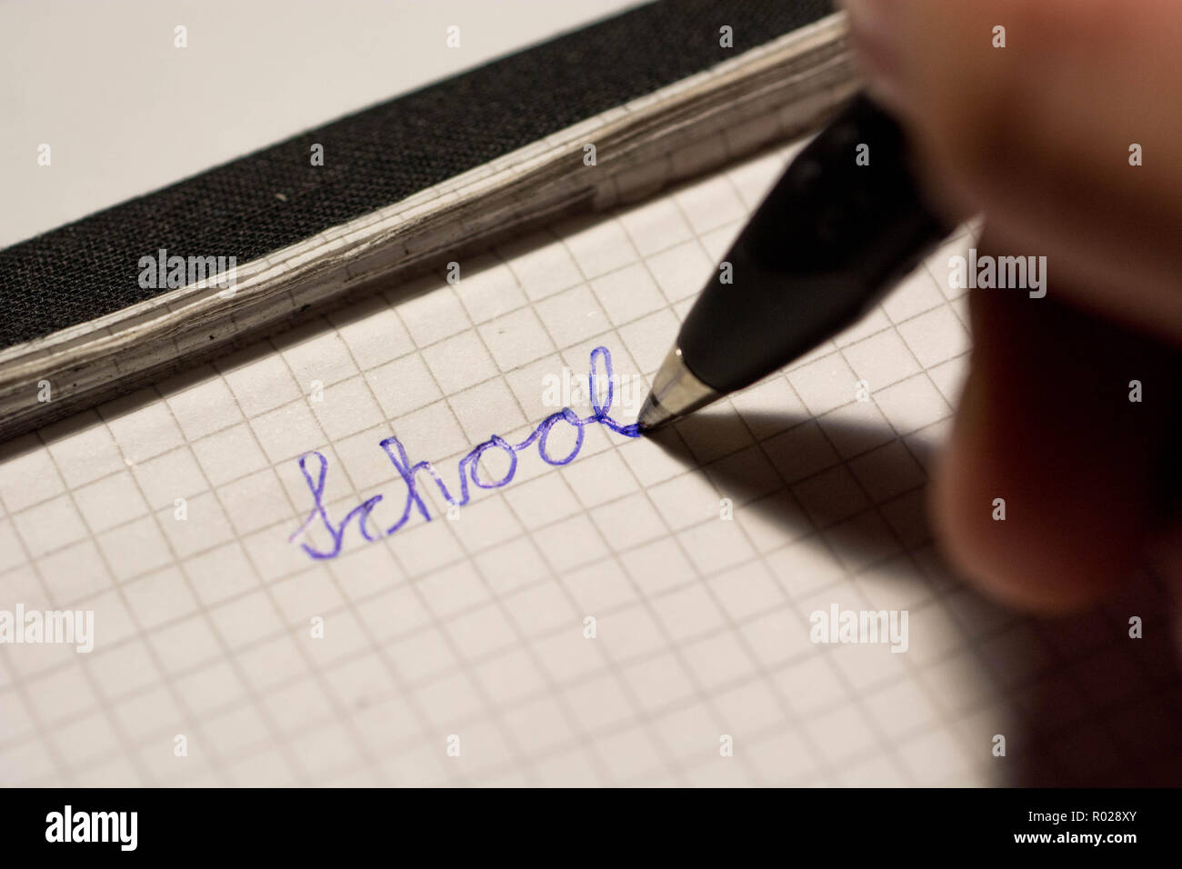 La main de l'école d'écriture sur le bloc-notes avec stylo à bille d'encre Banque D'Images