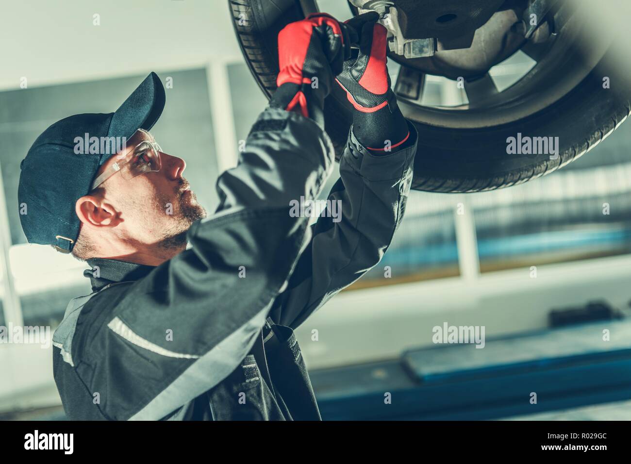 L'entretien du véhicule rotule par Professional Caucasian Mécanicien de voiture. L'industrie automobile. Banque D'Images